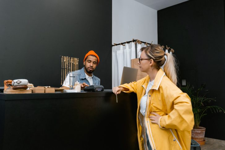 Woman in yellow jacket standing in front of a cashier
