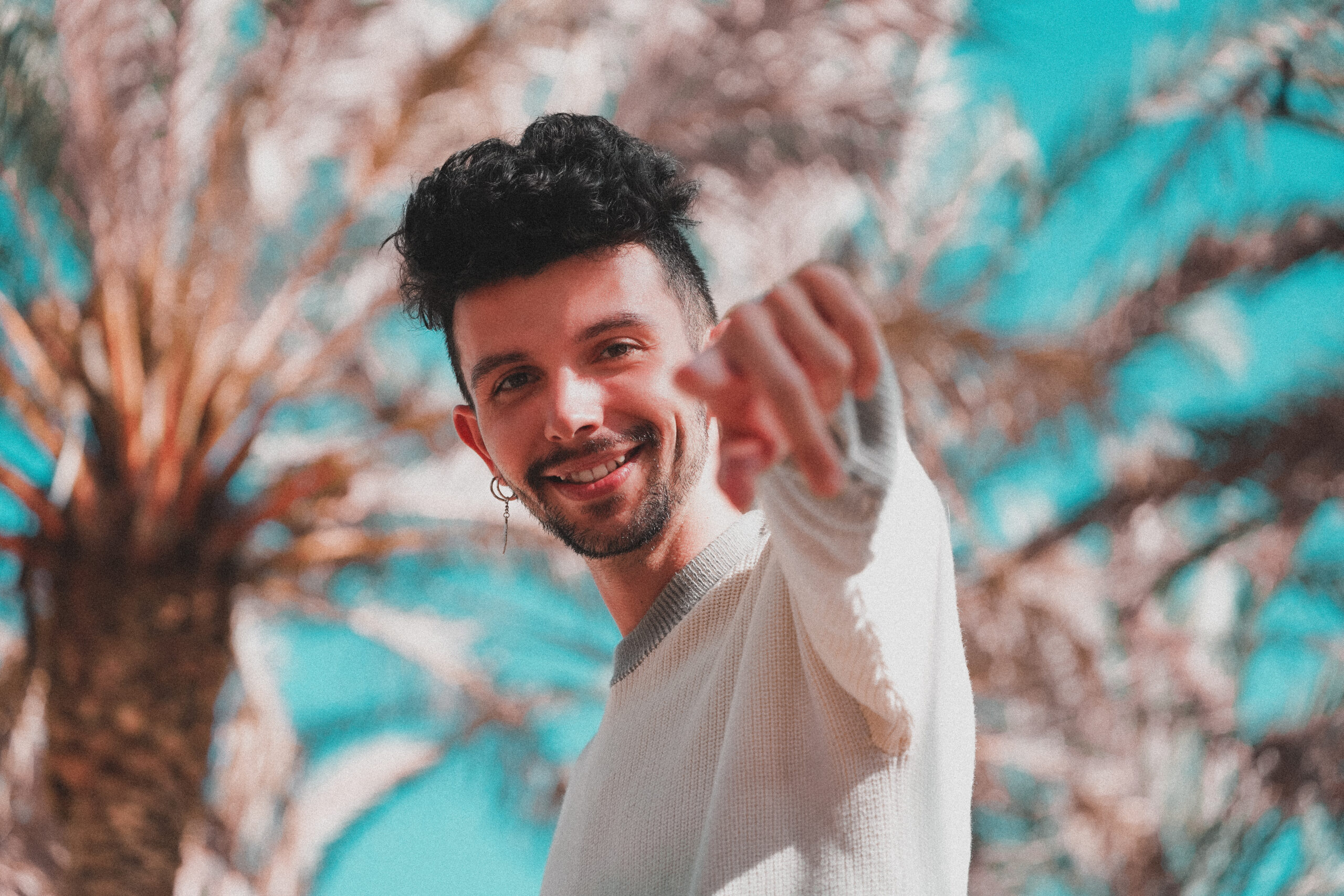 Handsome young guy pointing at camera in tropics