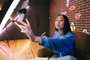 A woman using her phone while attached on a ring light